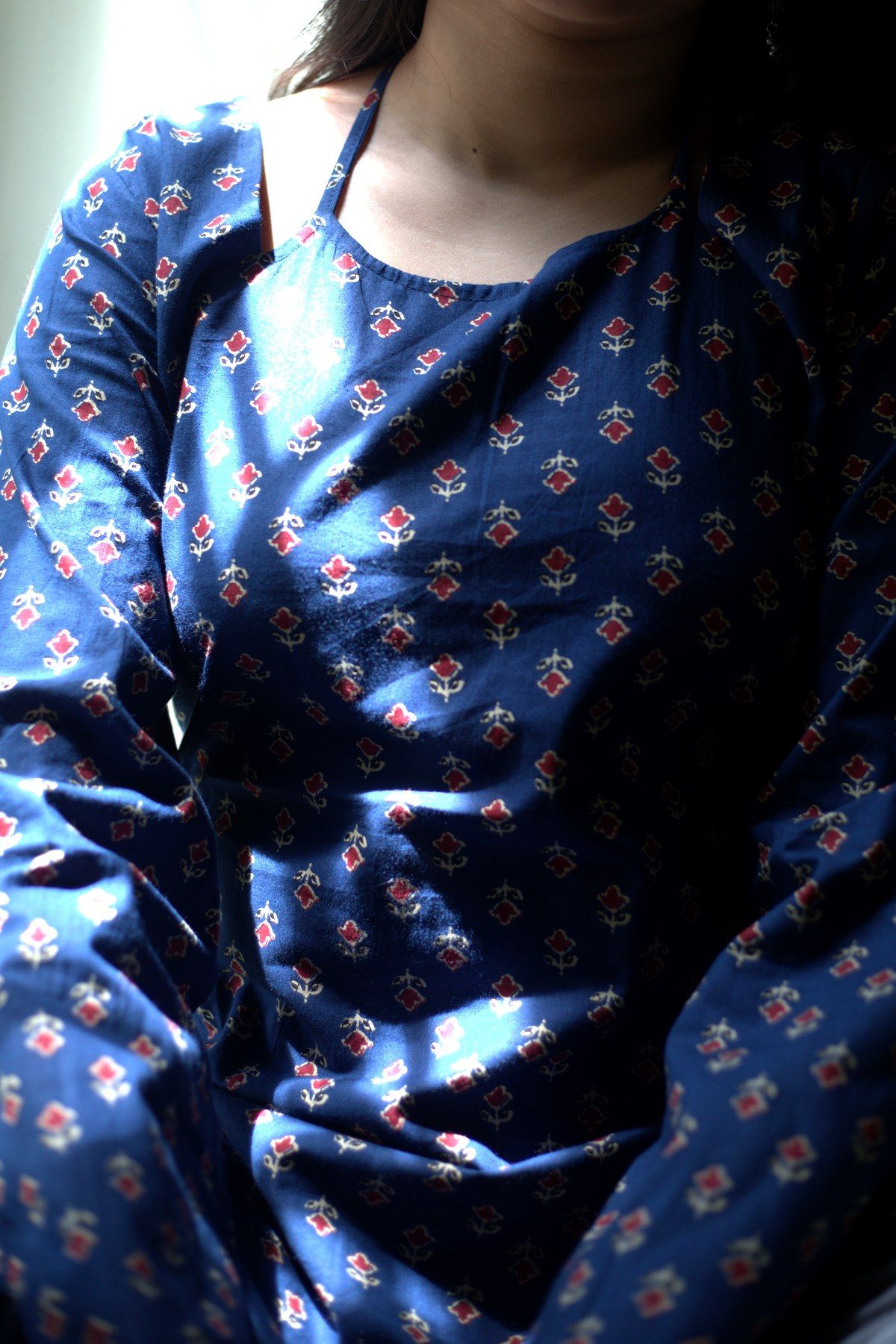 Close view of the neckline, halter tie and small buti print
