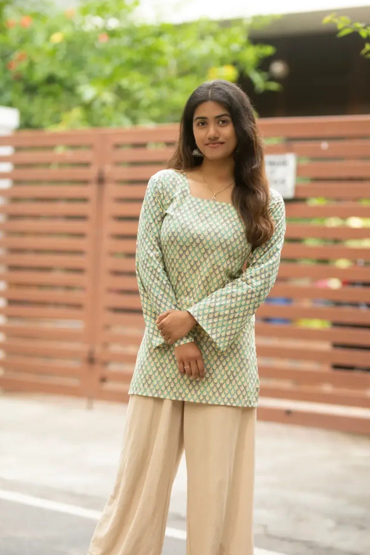 Full-length view of the sage scallop top worn with beige palazzo